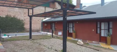 an outside view of a red brick building with a roof at El Elyon Duplex in Santa Rosa de Calamuchita