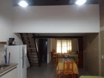 a kitchen and dining room with a table and a refrigerator at El Elyon Duplex in Santa Rosa de Calamuchita