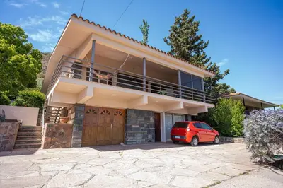 a small red car parked in front of a house at Casa en Carlos Paz con pileta in Villa Carlos Paz