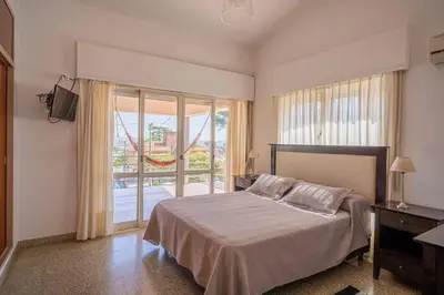 a bedroom with a bed and a large window at Casa en Carlos Paz con pileta in Villa Carlos Paz