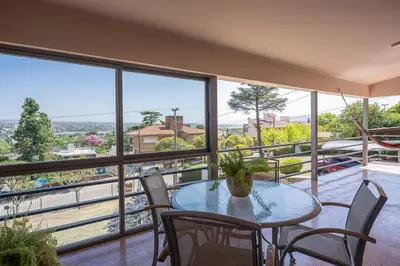 a table and chairs in a room with a large window at Casa en Carlos Paz con pileta in Villa Carlos Paz