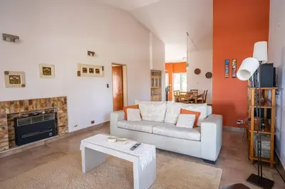 a living room with a white couch and a fireplace at Casa en Carlos Paz con pileta in Villa Carlos Paz