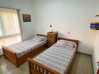 two beds sitting in a room with a window at Casa en Carlos Paz con pileta in Villa Carlos Paz