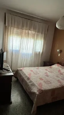 a bedroom with a bed and a window with a curtain at Casa en Villa Carlos Paz in Villa Carlos Paz