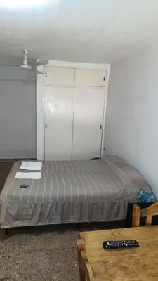a small bedroom with a bed and a table at Departamento para 2 personas in Bialet Massé