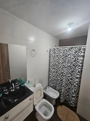 a bathroom with a toilet and a black and white shower curtain at Departamento en Córdoba in Cordoba