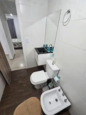 a white bathroom with a toilet and a sink at Departamento en Córdoba in Cordoba