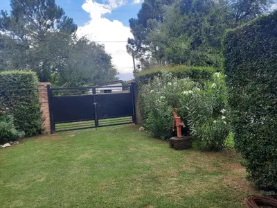 a garden with a gate and some bushes at El Marino in Merlo