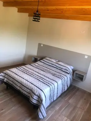 a bedroom with a bed with a striped blanket on it at Cuatro Elementos Housing in Villa Parque Siquiman