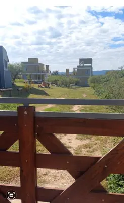 a wooden fence with buildings in the background at Cuatro Elementos Housing in Villa Parque Siquiman