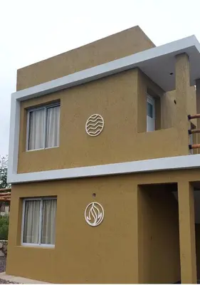 a building with two pizzas on the side of it at Cuatro Elementos Housing in Villa Parque Siquiman