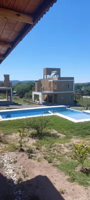 a large swimming pool with a house in the background at Cuatro Elementos Housing in Villa Parque Siquiman
