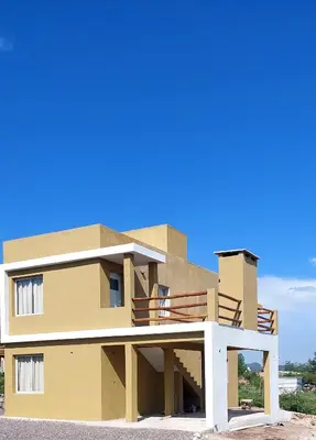 a building with a blue sky in the background at Cuatro Elementos Housing in Villa Parque Siquiman