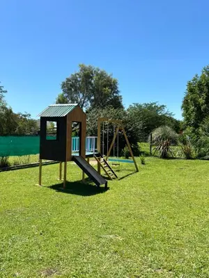 a playground with a slide in the grass at Cabañas Dos Soles in Cordoba