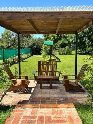 a wooden pergola with two chairs and a bench at Cabañas Dos Soles in Cordoba