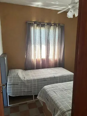 two twin beds in a room with a window at Cabañas Dos Soles in Cordoba