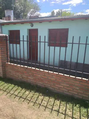 a brick fence in front of a house at Departamento NataFeli in Santa Rosa de Calamuchita