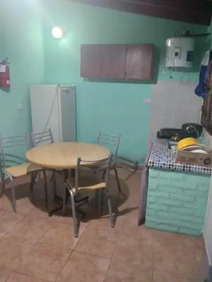 a kitchen with a table and chairs and a refrigerator at Departamento NataFeli in Santa Rosa de Calamuchita