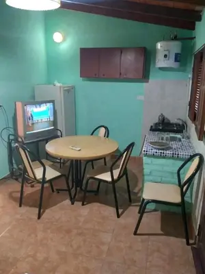 a room with a table and chairs and a television at Departamento NataFeli in Santa Rosa de Calamuchita