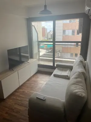 a living room with a couch and a large window at Dpto p 3 en pleno Nva. Córdoba in Cordoba