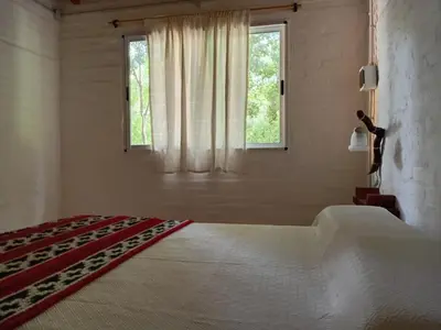 a white bedroom with a large bed and a window at Cheroga in Trapiche