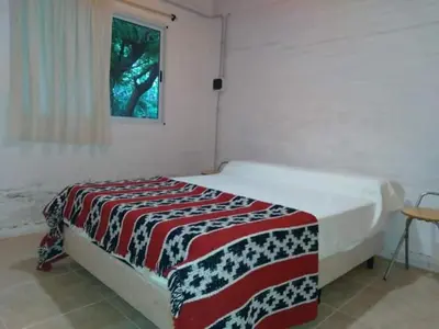 a bedroom with a bed with a red white and black blanket at Cheroga in Trapiche