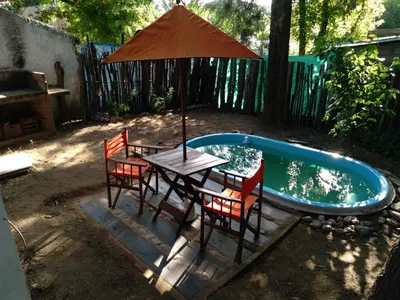 a table and chairs with an umbrella next to a pool at Cheroga in Trapiche