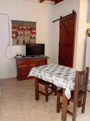 a dining room with a table and a tv at Cheroga in Trapiche