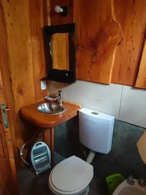 a bathroom with a wooden sink and a toilet at La Cabañita in Tanti