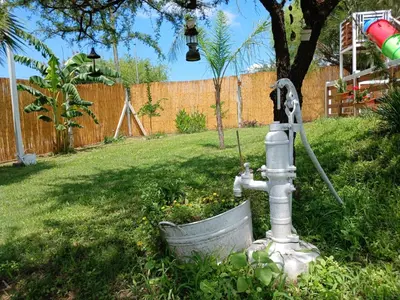 a water fountain in a yard with a bucket at Atardeceres del Valle in La Bolsa