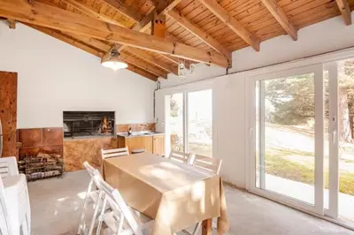 a dining room with a table and a fireplace at Hermosa Casa V. General Belgrano in Villa General Belgrano