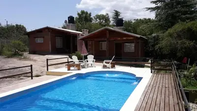 a swimming pool in front of a house at Cabañas Las Marias 1 in Cordoba