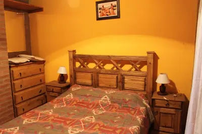 a bedroom with a bed and two nightstands and two lamps at Cabañas Las Marias 1 in Cordoba