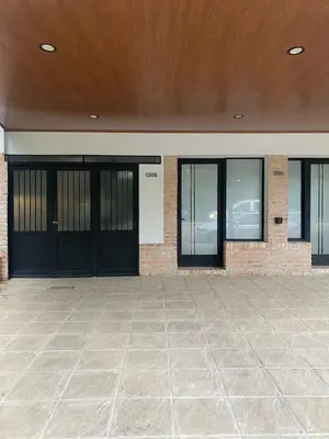 an empty building with black doors and a tile floor at Casa Raíz 2 habitaciones para 4 personas frente al río in Santa Rosa de Calamuchita