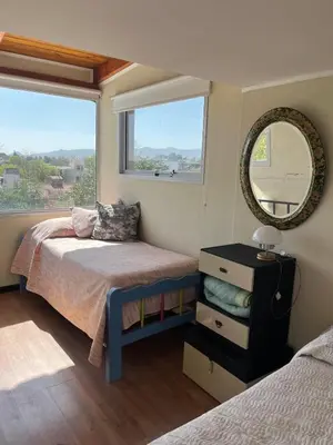 a bedroom with a bed and a mirror and a window at Casa Beethoven in Villa Carlos Paz
