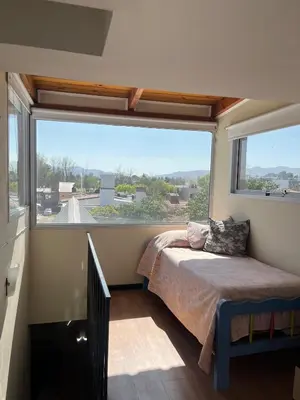 a bedroom with a bed and a large window at Casa Beethoven in Villa Carlos Paz