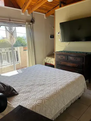 a bedroom with a bed and a flat screen tv at Casa Beethoven in Villa Carlos Paz