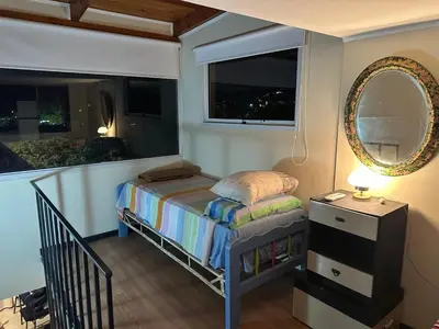 a small bedroom with a bed and a mirror at Casa Beethoven in Villa Carlos Paz