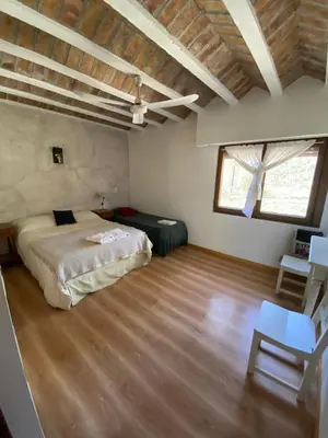 a bedroom with a bed and a wooden floor at Hotel Prater in Villa General Belgrano
