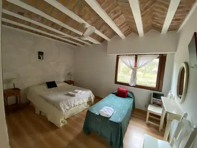 a bedroom with a bed and a table and a window at Hotel Prater in Villa General Belgrano