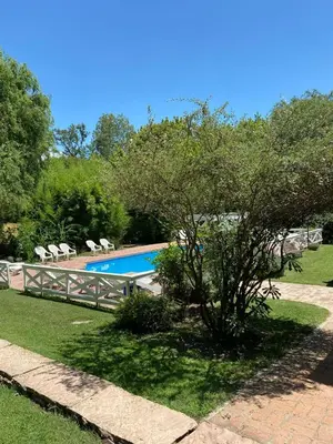 a tree in front of a swimming pool at Hotel Prater in Villa General Belgrano
