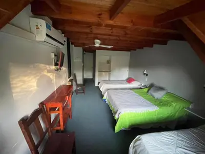 a room with two beds and a desk and a room with two beds at Hotel Prater in Villa General Belgrano
