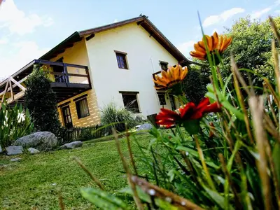 a house on a hill with flowers in front of it at la matilda in Santa Rosa de Calamuchita