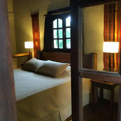 a bedroom with a bed with a window and two lamps at la matilda in Santa Rosa de Calamuchita