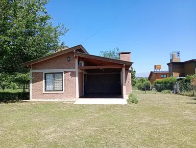 a small house with a garage in a yard at Casa Erica in Santa Rosa de Calamuchita