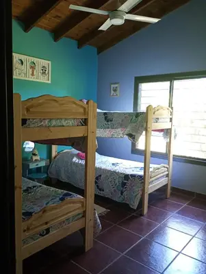 a bedroom with two bunk beds and a window at Casa Erica in Santa Rosa de Calamuchita