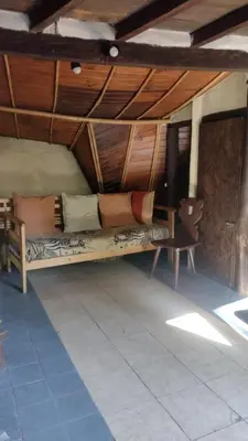 a couch in a room with a table and a chair at Casitas del arroyo Actividades Arte Cultura y descanso en Villa General Belgrano in Villa General Belgrano