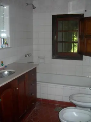 a bathroom with two sinks and a toilet and a window at Tunquelen in Las Calles