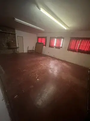an empty room with red windows and a room with a wooden floor at Tunquelen in Las Calles
