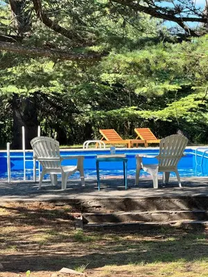 two chairs and a table in front of a pool at Tunquelen in Las Calles